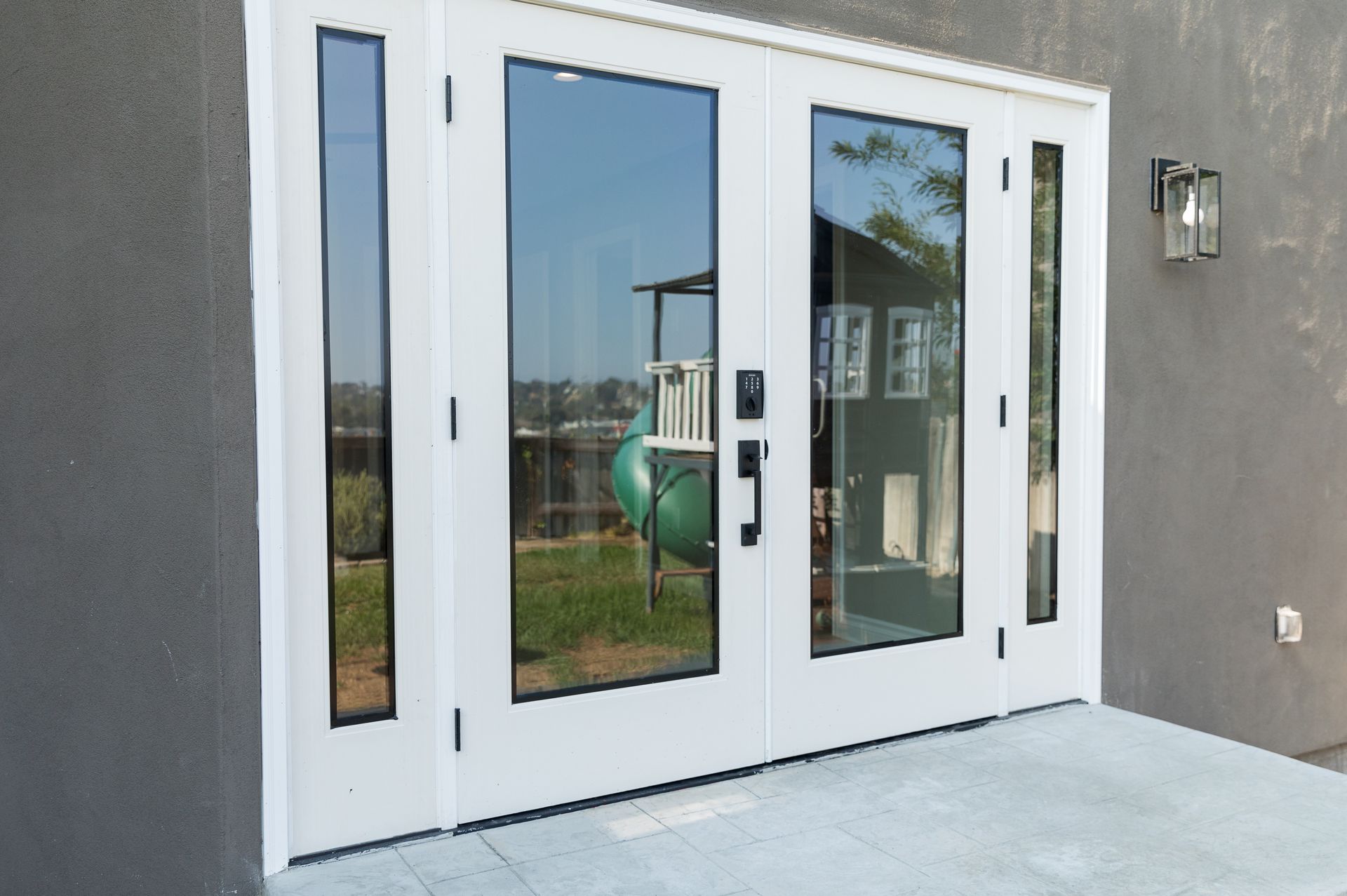 A white door with a lot of glass is on the side of a building.