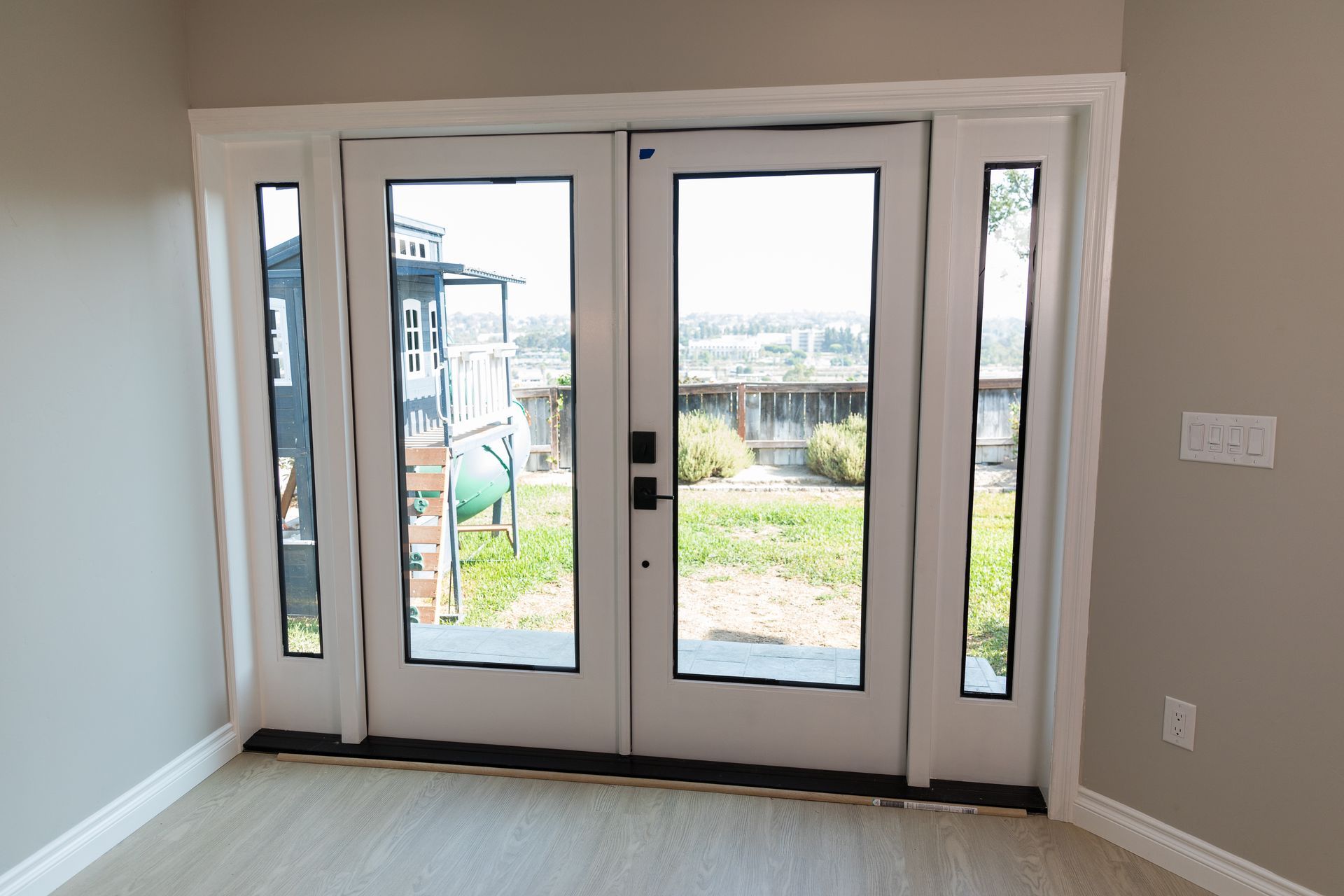 An empty room with a white door and a lot of windows.