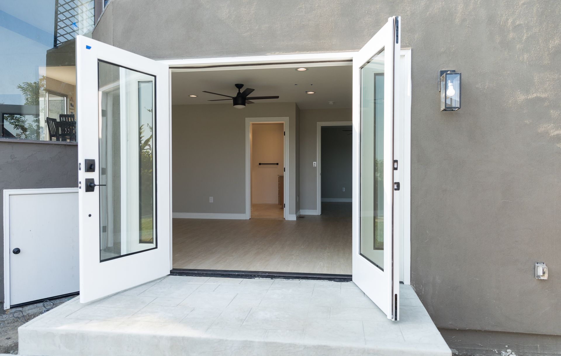 A white door is open to a room with a ceiling fan