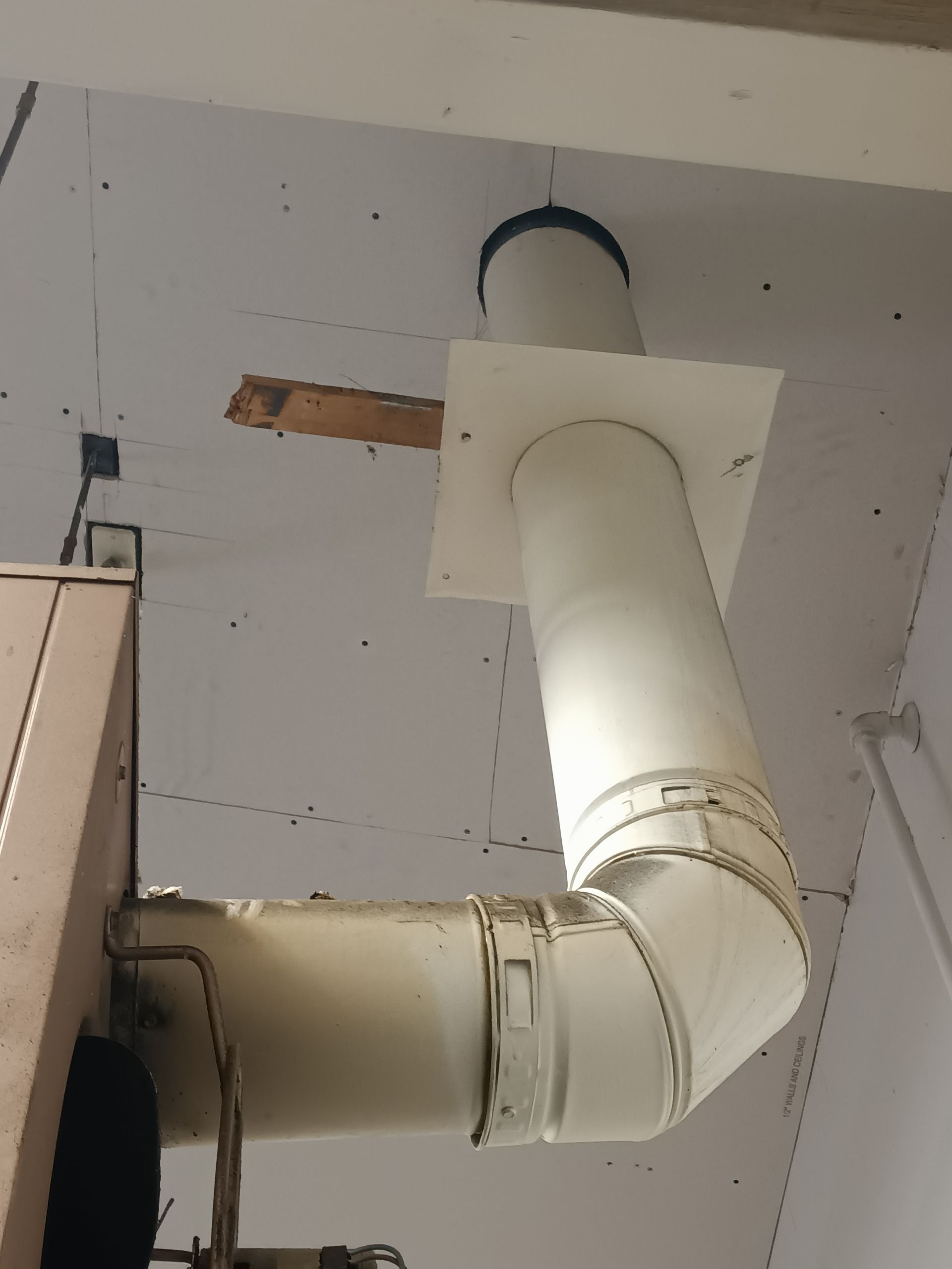 A white pipe is hanging from the ceiling of a building