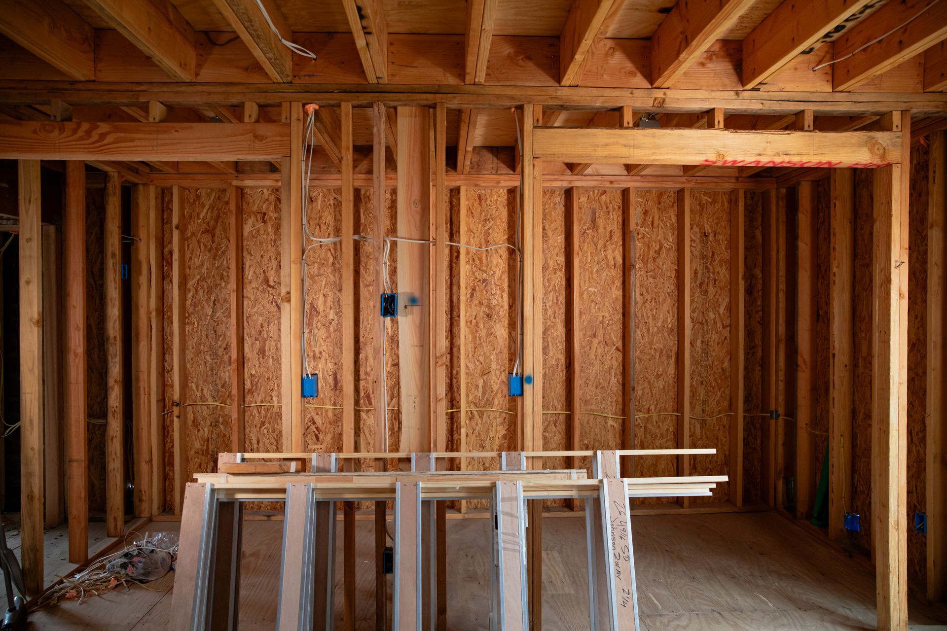 A room in a house under construction with wooden beams.