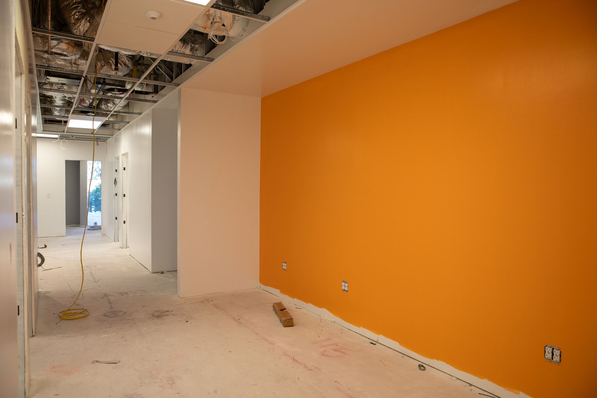 An empty room with orange walls and white walls.