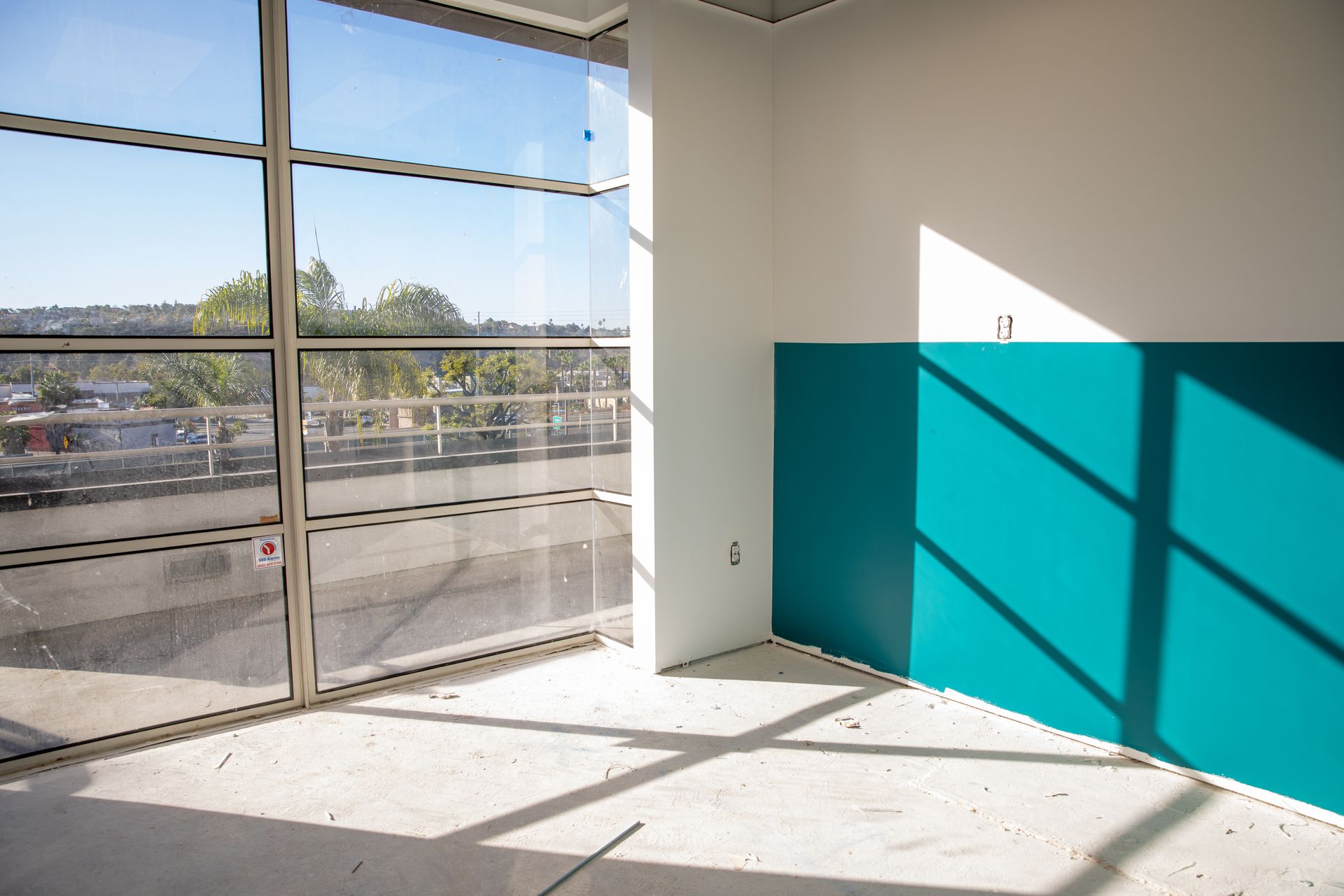 An empty room with a blue wall and a large window