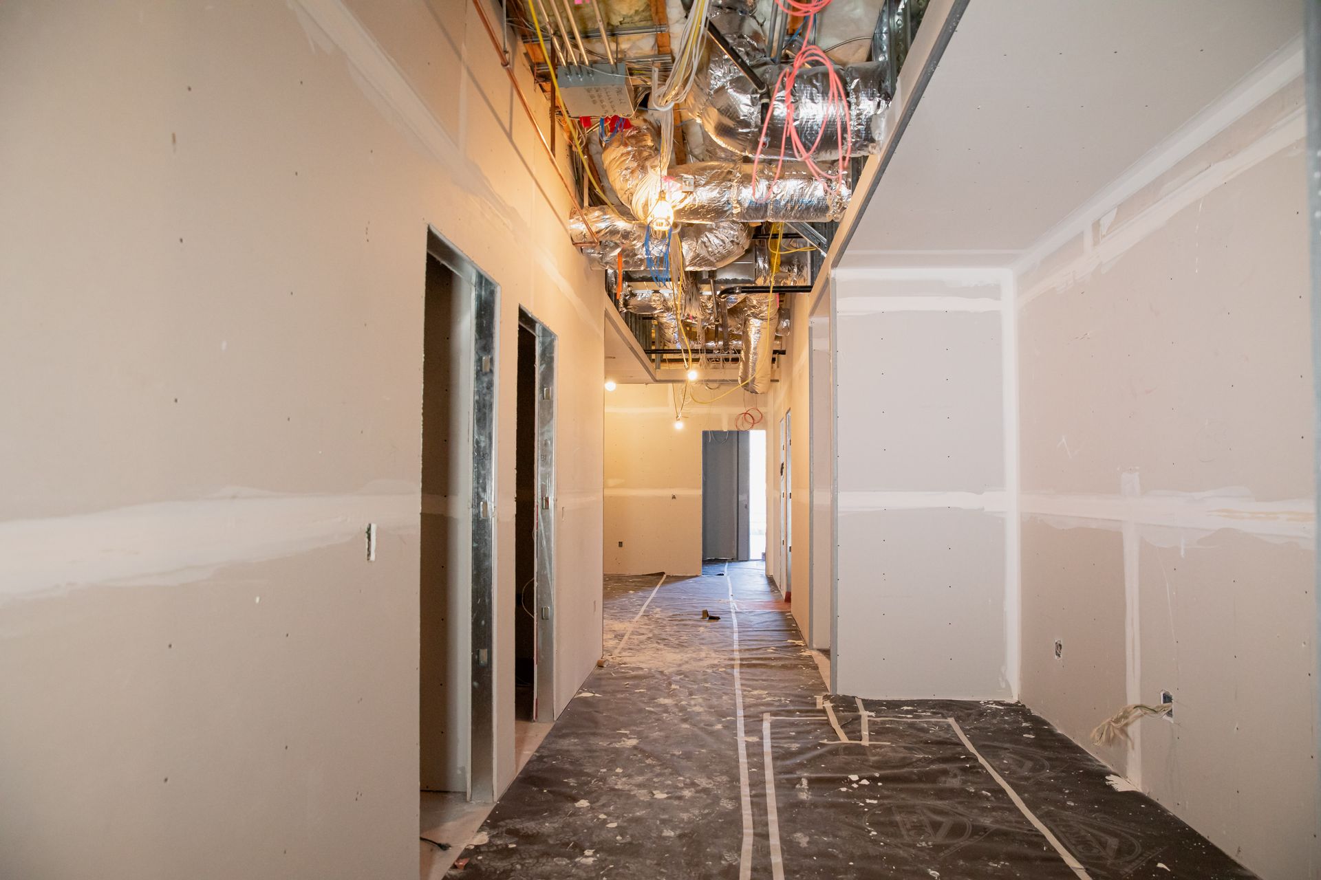An empty hallway with drywall walls and a ceiling in a building under construction.