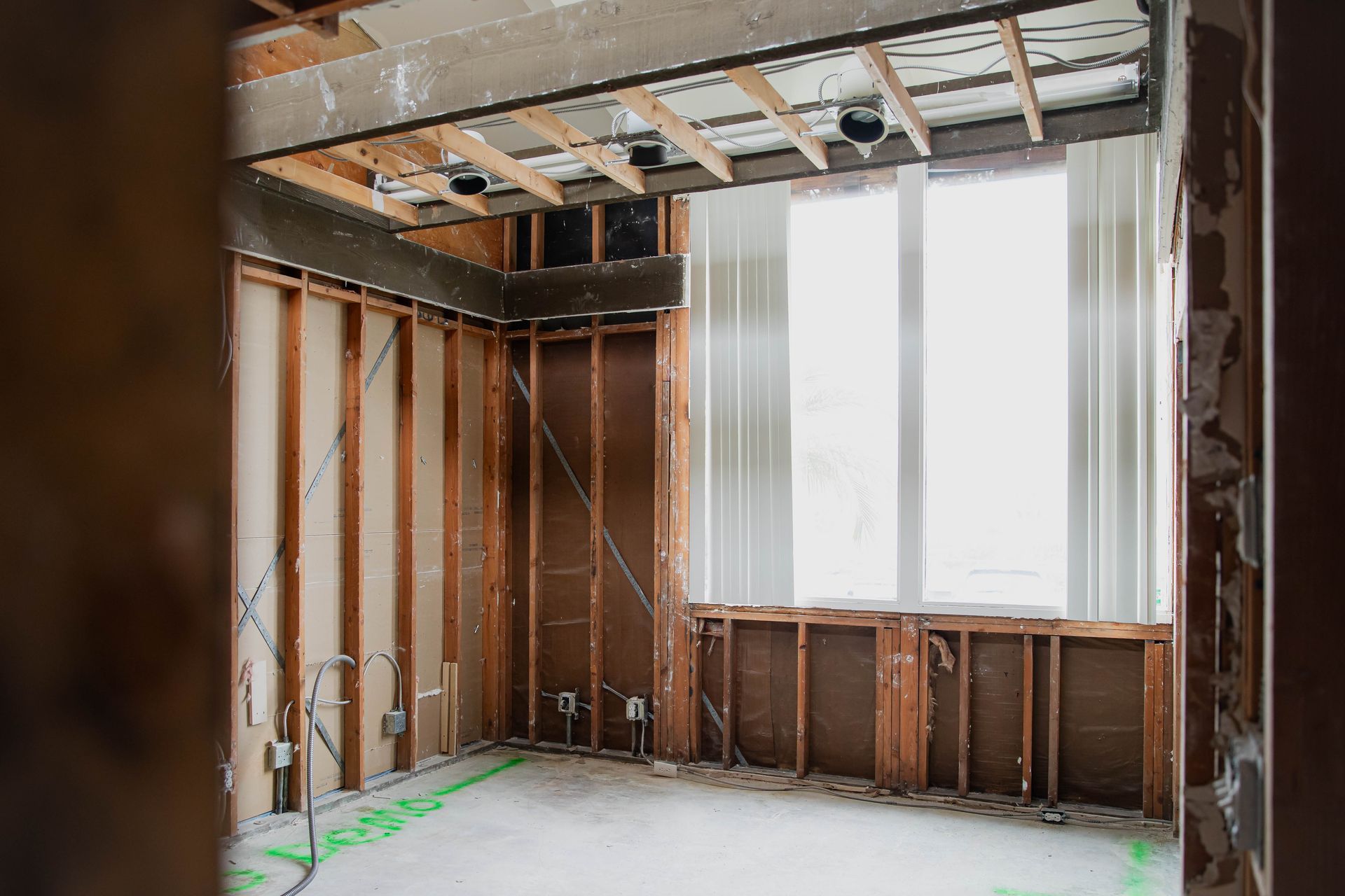 An empty room with wooden walls and a window under construction.