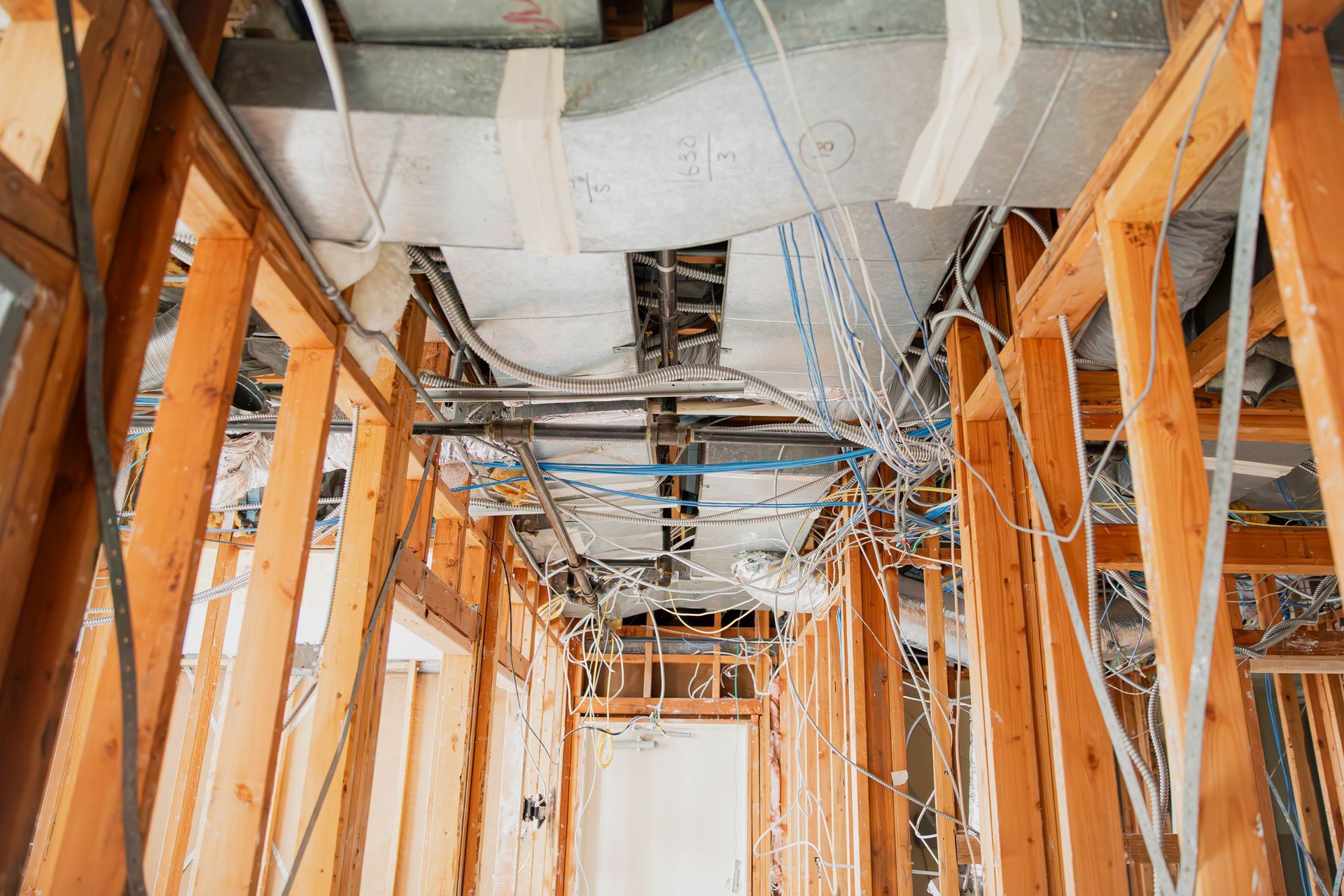 A building under construction with a lot of wires hanging from the ceiling.