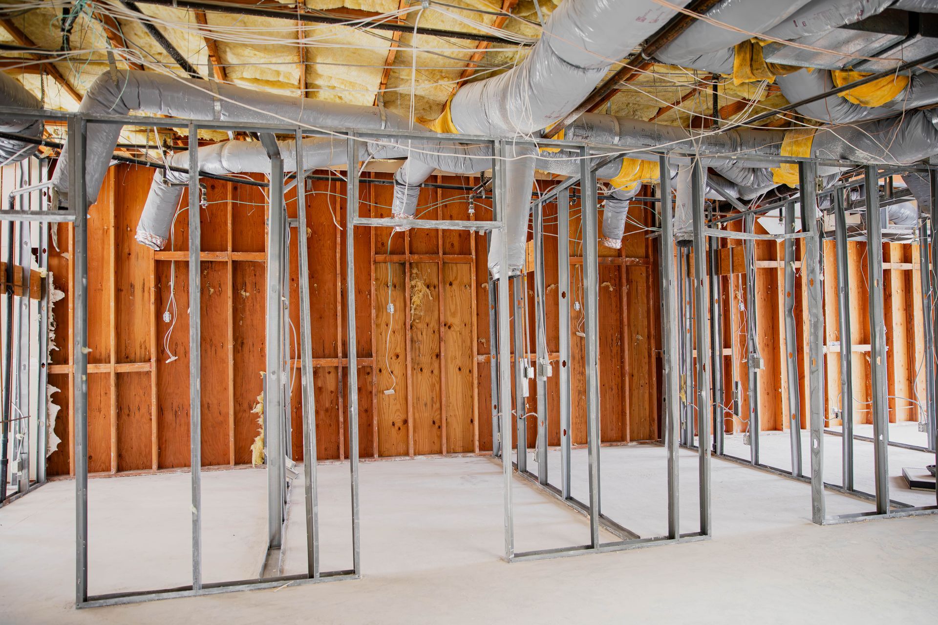 An empty room with a lot of pipes hanging from the ceiling.