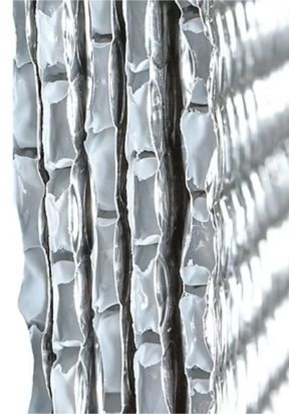 Silver, textured material in vertical rows, resembling a cross-section or close-up of something intricate.