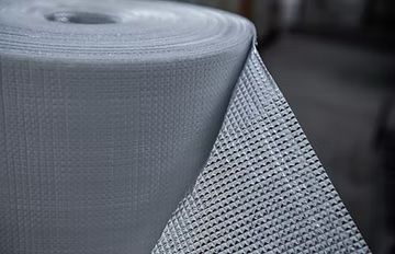 Roll of gray woven fabric, possibly fiberglass.