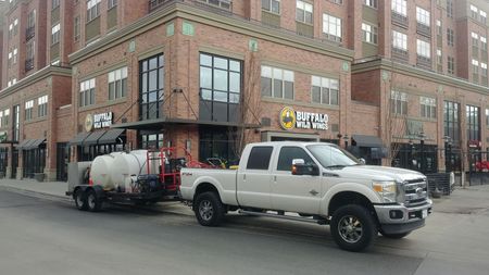Professional pressure washing company vehicle and trailer parked for commercial job