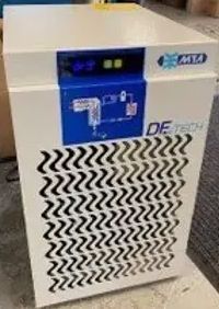 A white air compressor with a blue and black pattern on it is sitting on a table.