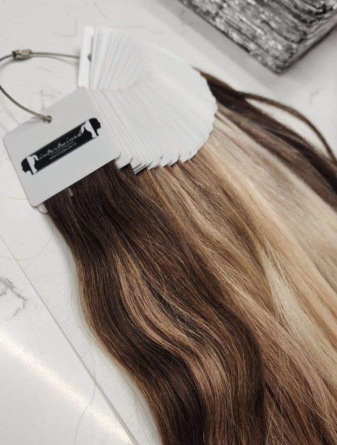 Hair extensions color swatches, shades of brown and blonde, on a white surface.
