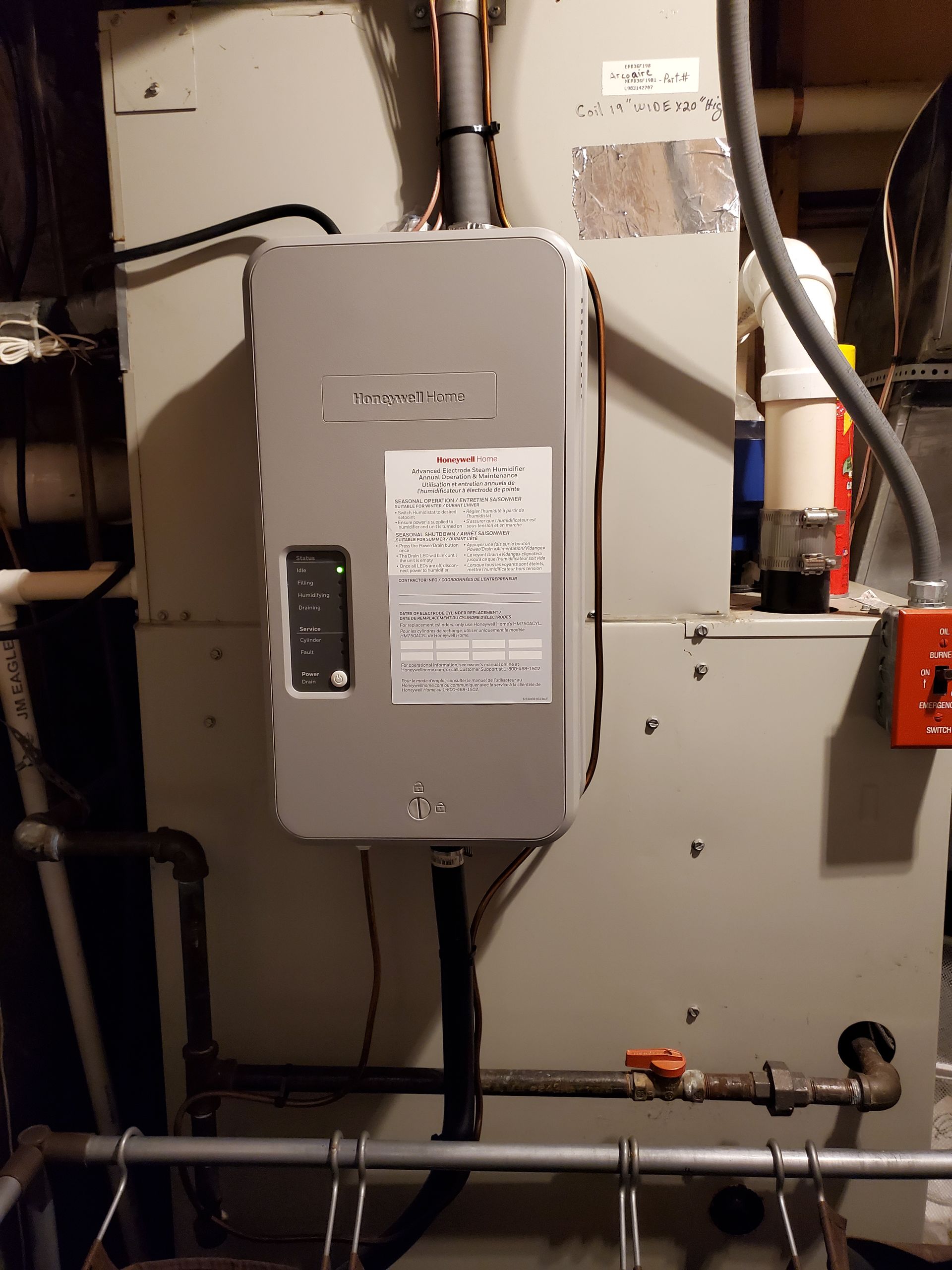 A water heater is hanging on a wall in a basement.