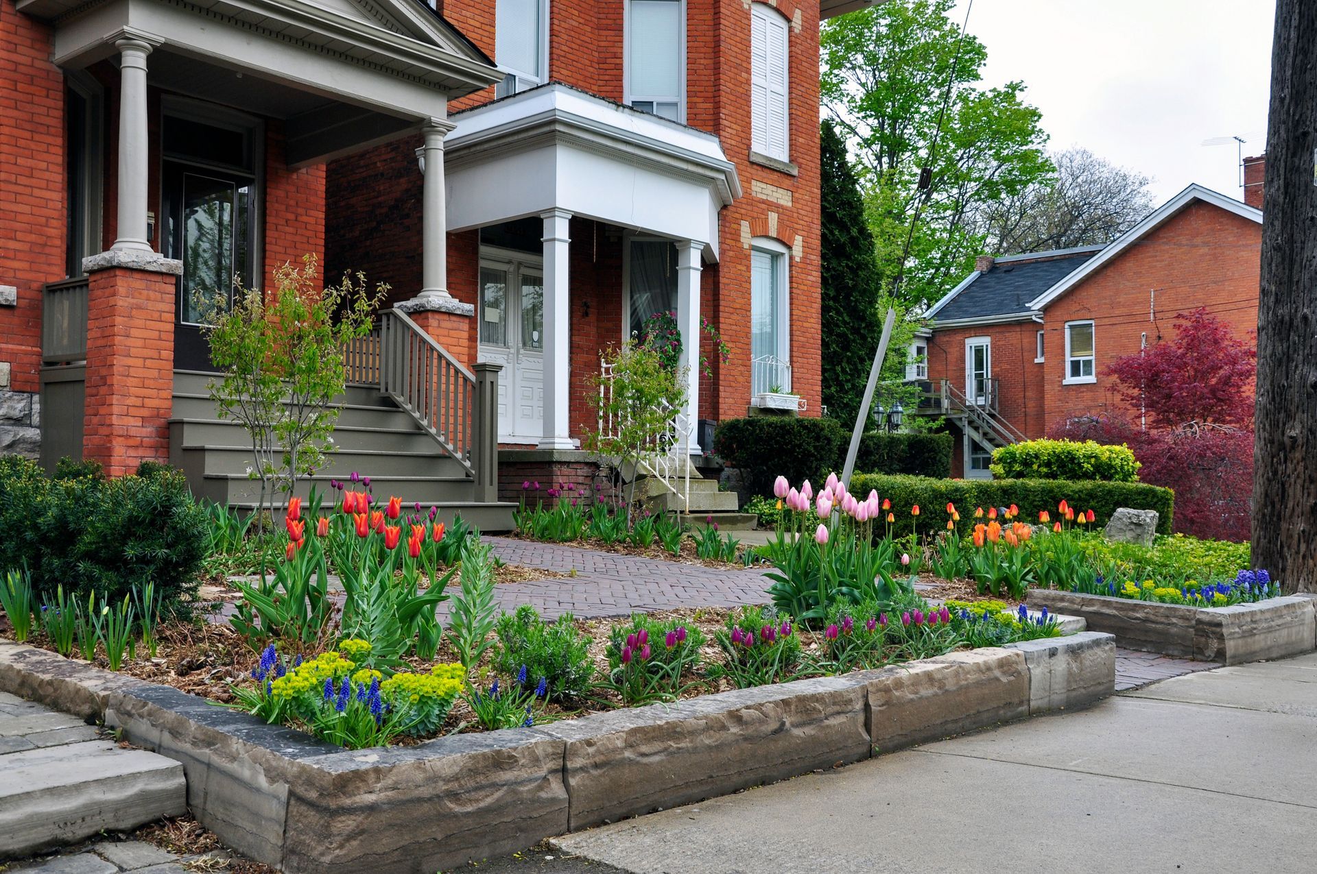 A brick house with a garden in front of it