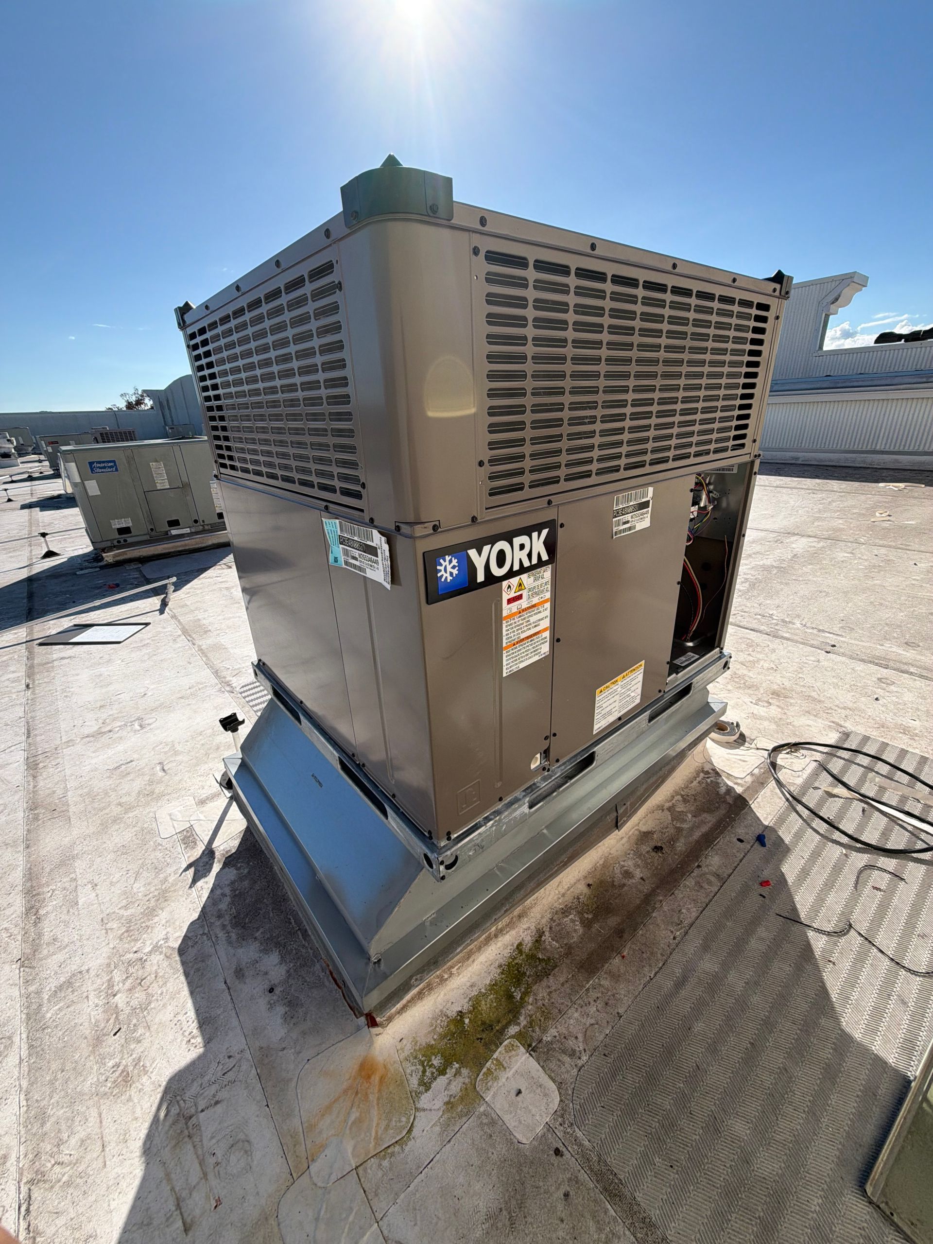 York rooftop HVAC unit on a snowy, sunlit rooftop with a York logo and louvered vents