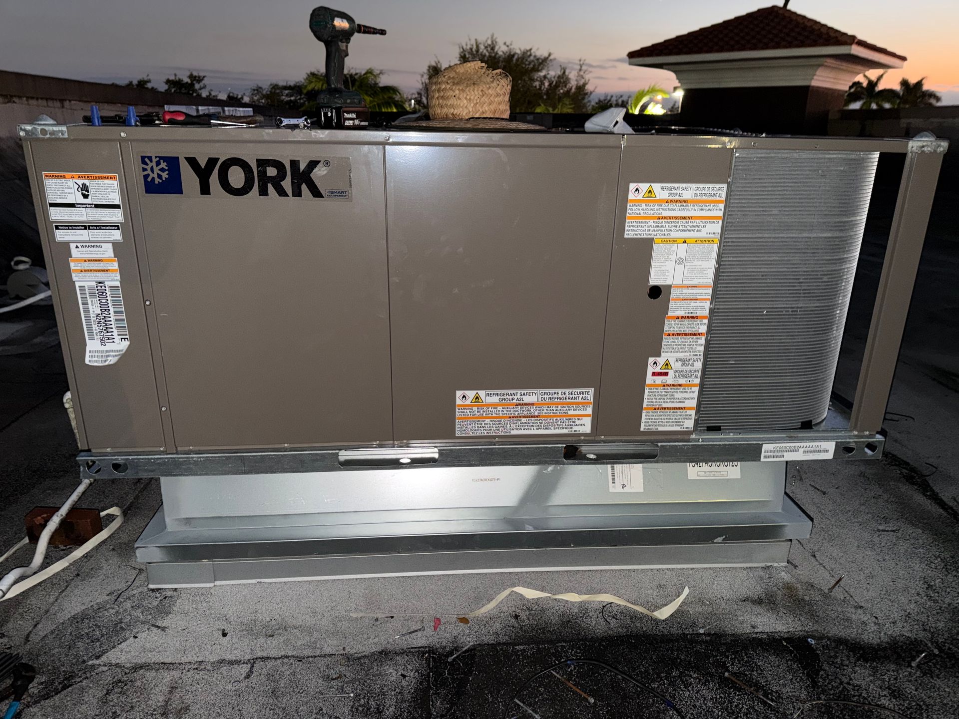 Outdoor YORK HVAC unit on a concrete pad with visible labels and surrounding piping.