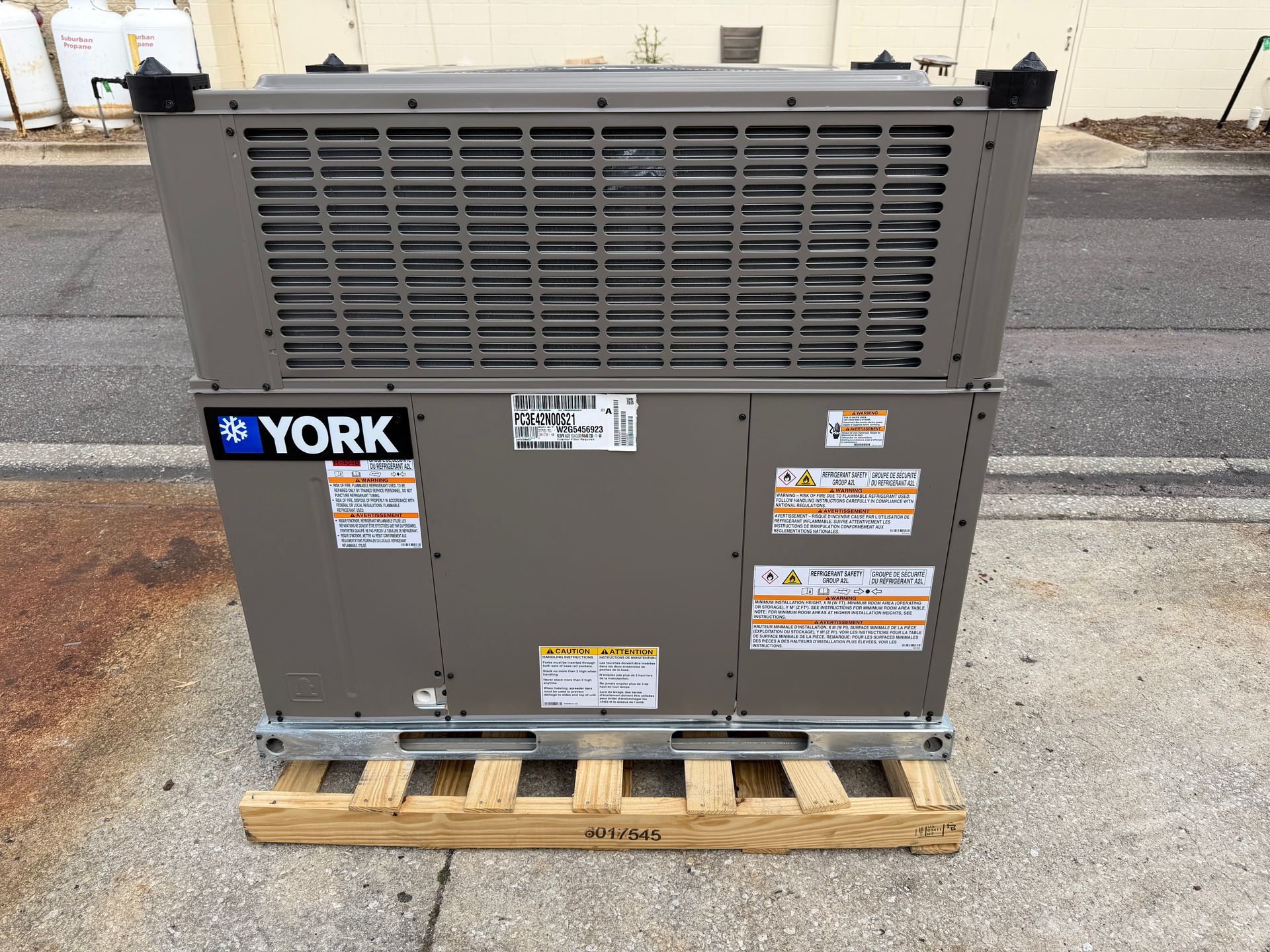 York HVAC unit on a wooden pallet outdoors against a concrete wall.