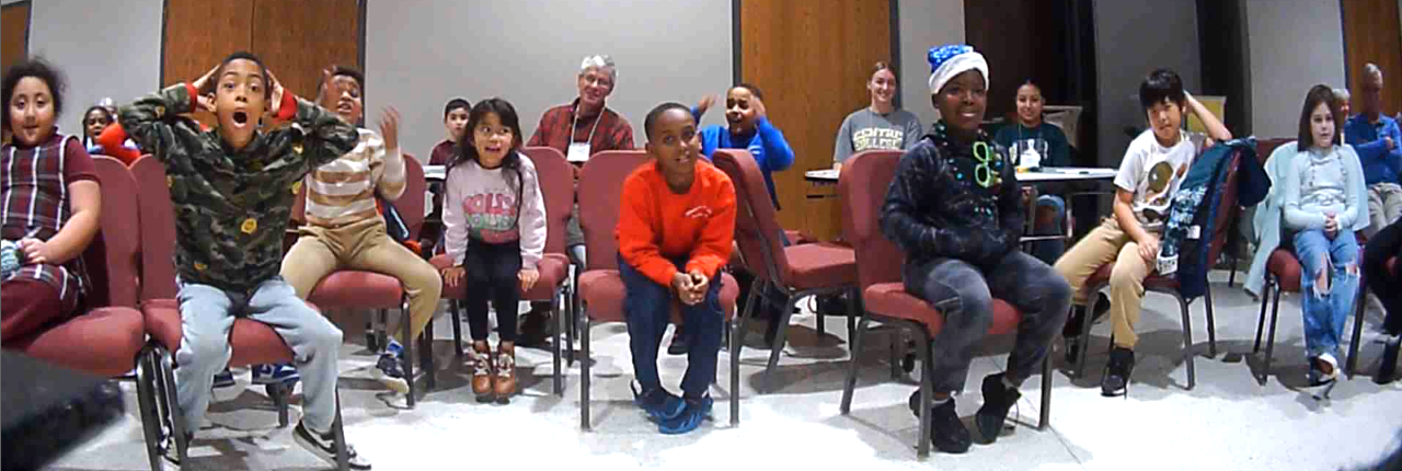 Group of seated audience members excited during magic show