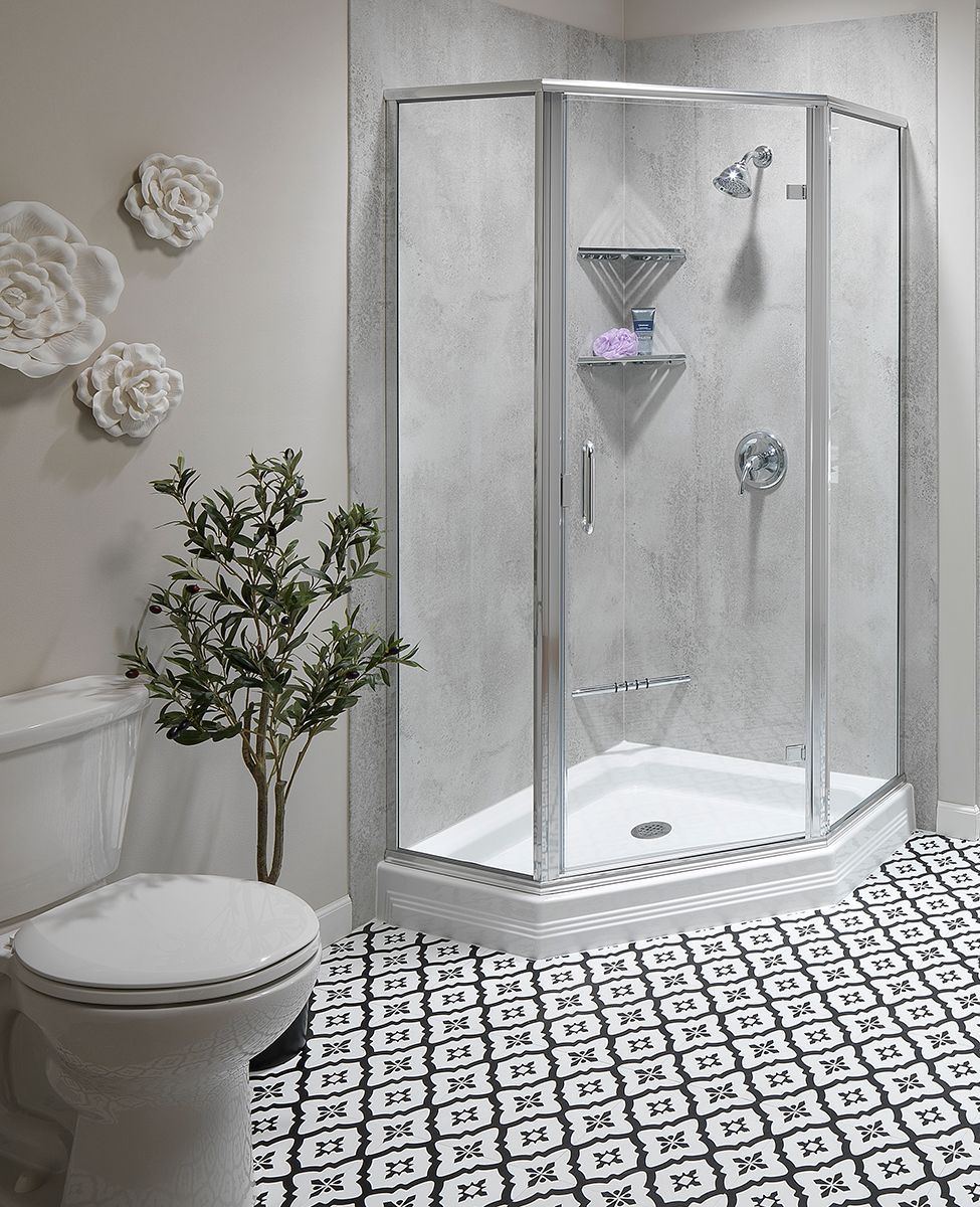 Woman in a modern bathroom holding a tablet beside a shower, sink, and window.