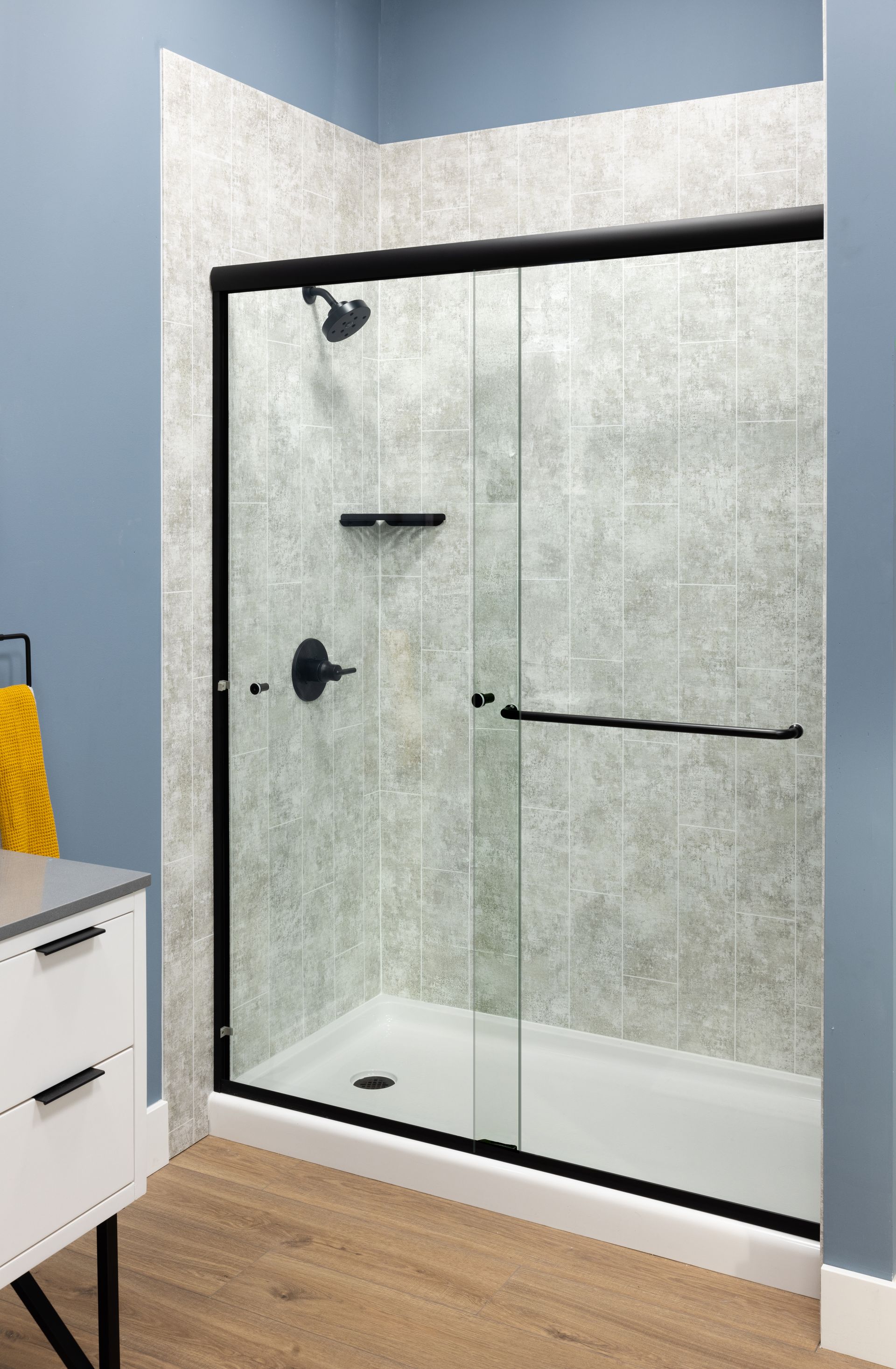 Modern bathroom with freestanding tub, dark wood vanity, toilet, mirror, and light gray tile floor