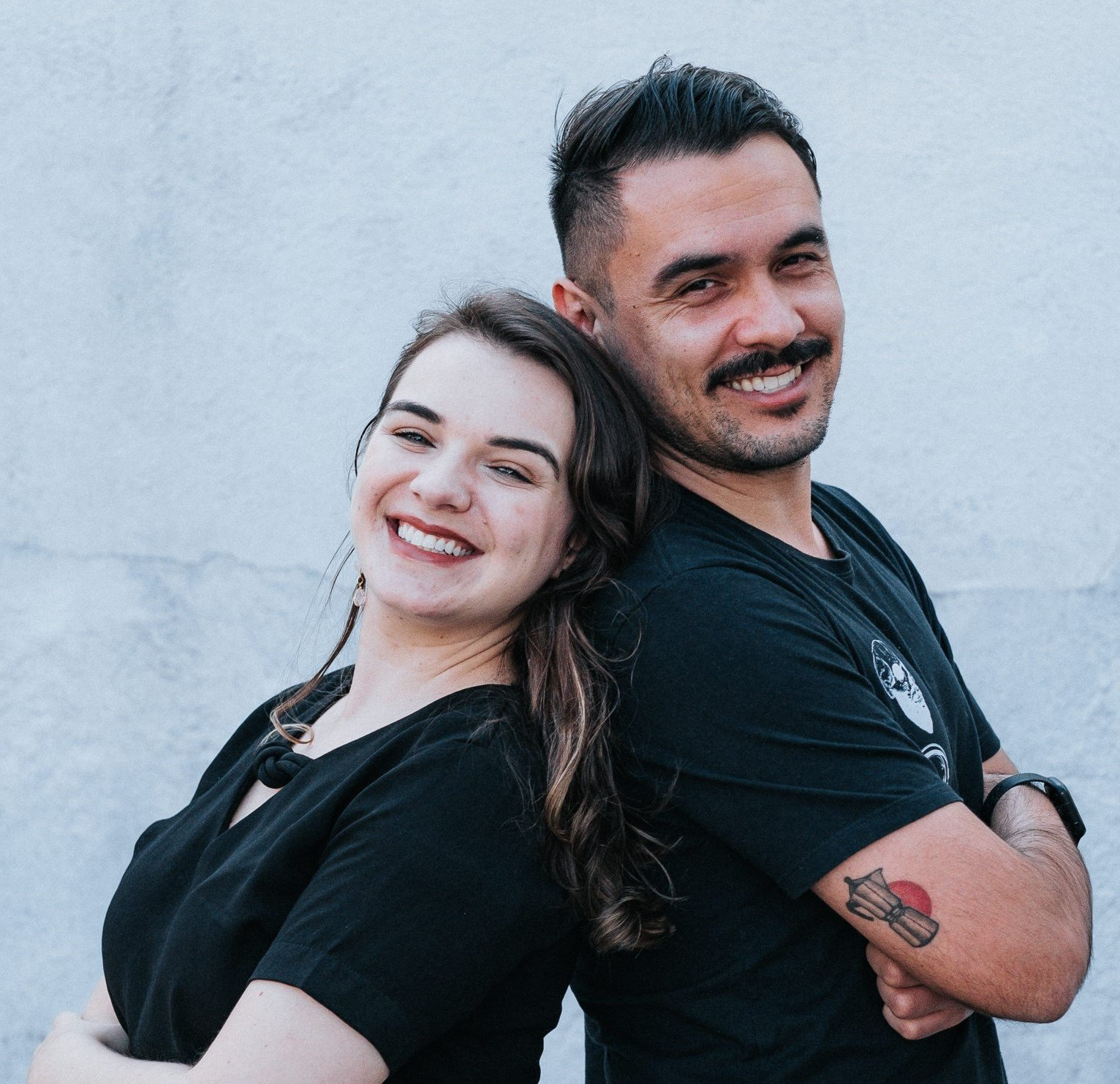 Um homem e uma mulher posam para uma foto com os braços cruzados