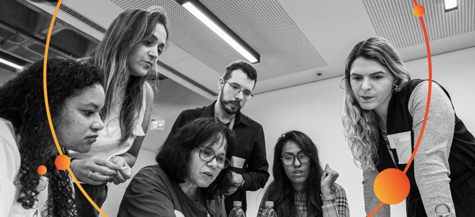 grupo de pessoas olhando para mesa com papéis