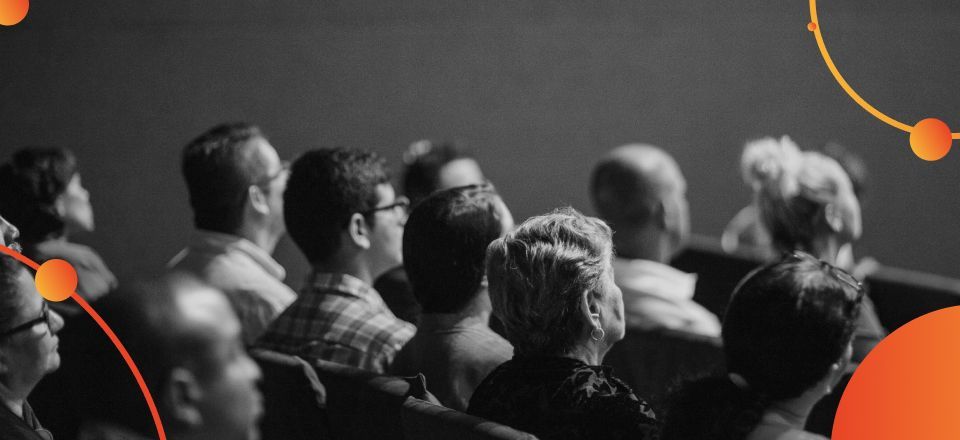 Um grupo de pessoas está sentado em um cinema assistindo a um filme.