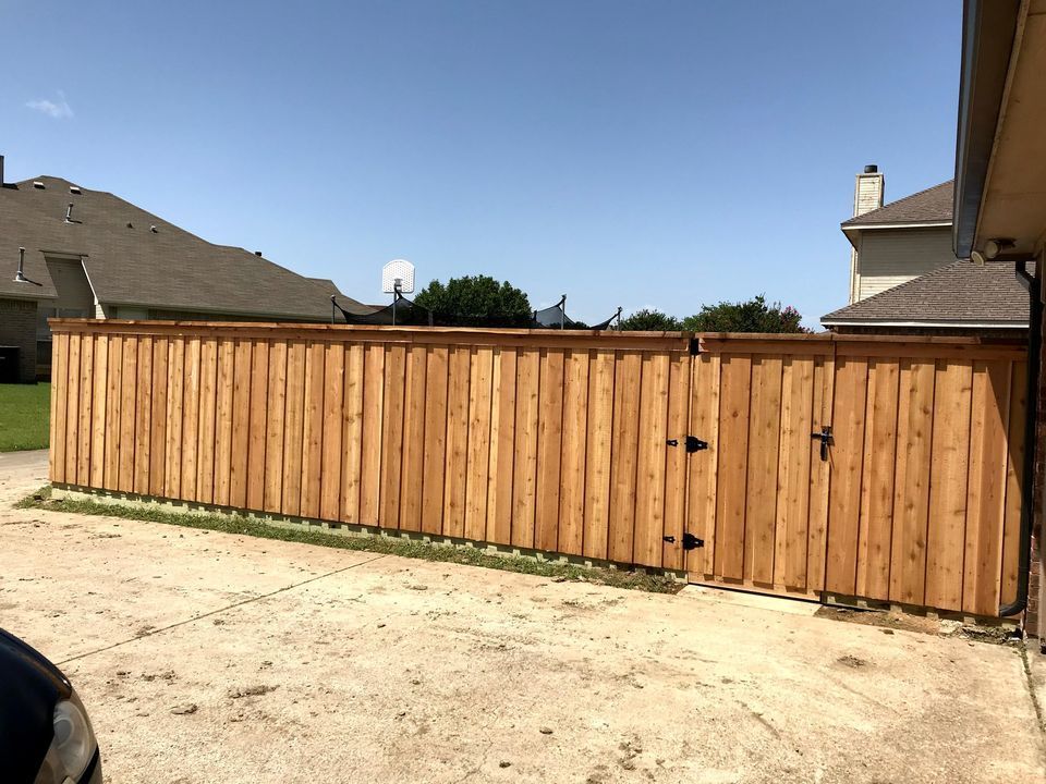 Wooden privacy fence with gate in a suburban backyard under a clear sky