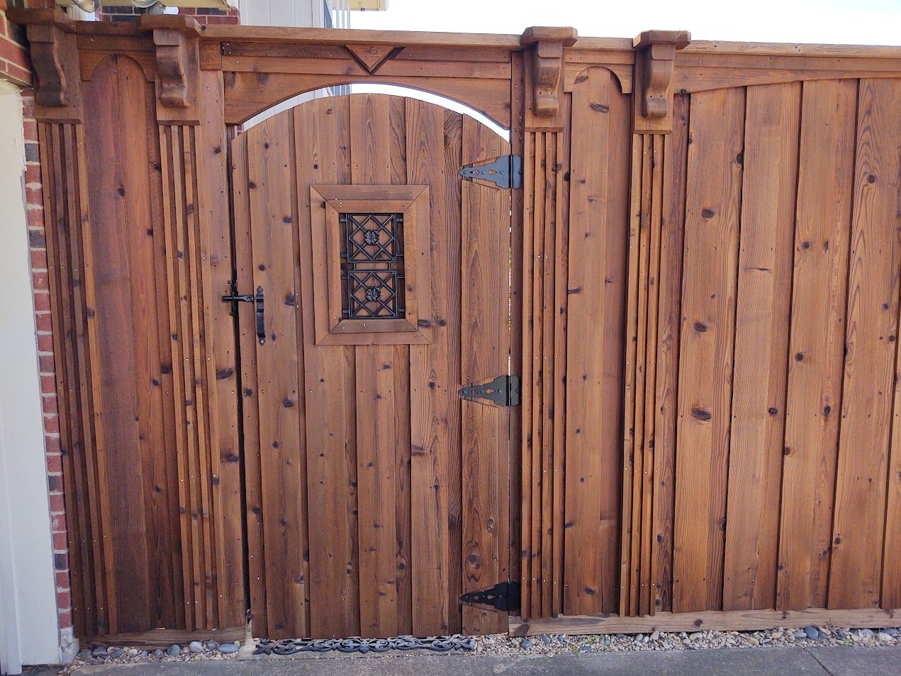 Wooden gate and fence with arched top and small decorative window