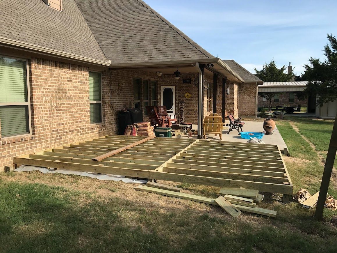 Back patio with stone pavers, covered porch, and yard in a suburban home