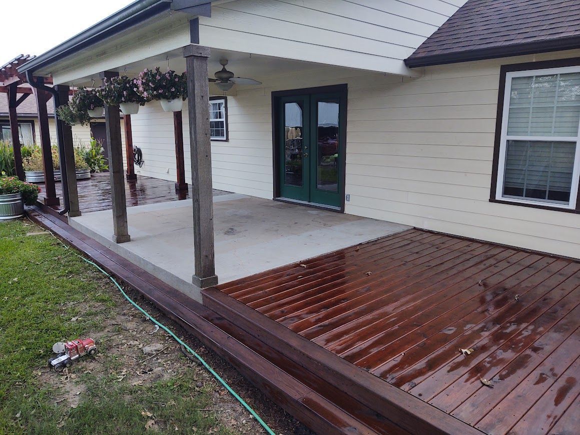 Covered porch with wooden deck and ramp beside a beige house