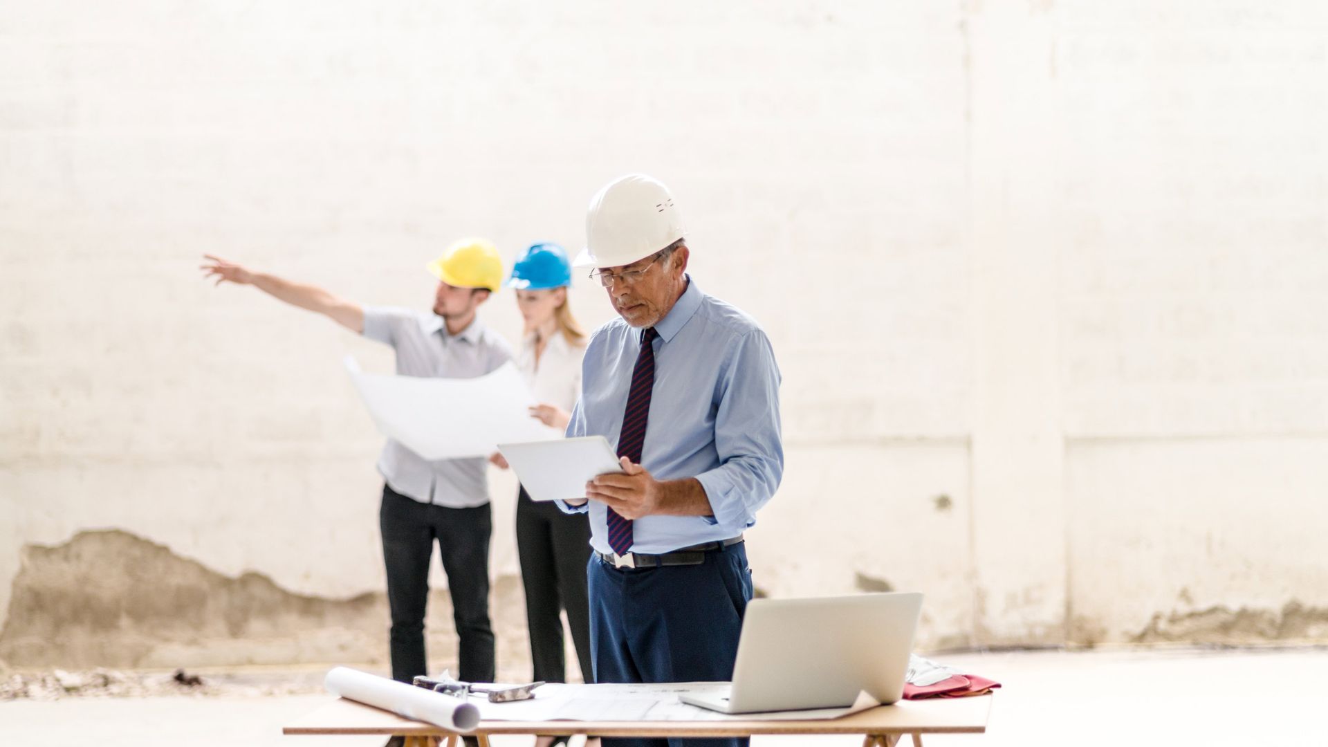 Man with white helmet looking at the building plan | Sydney, NSW | Soilsrock Engineering Pty Ltd