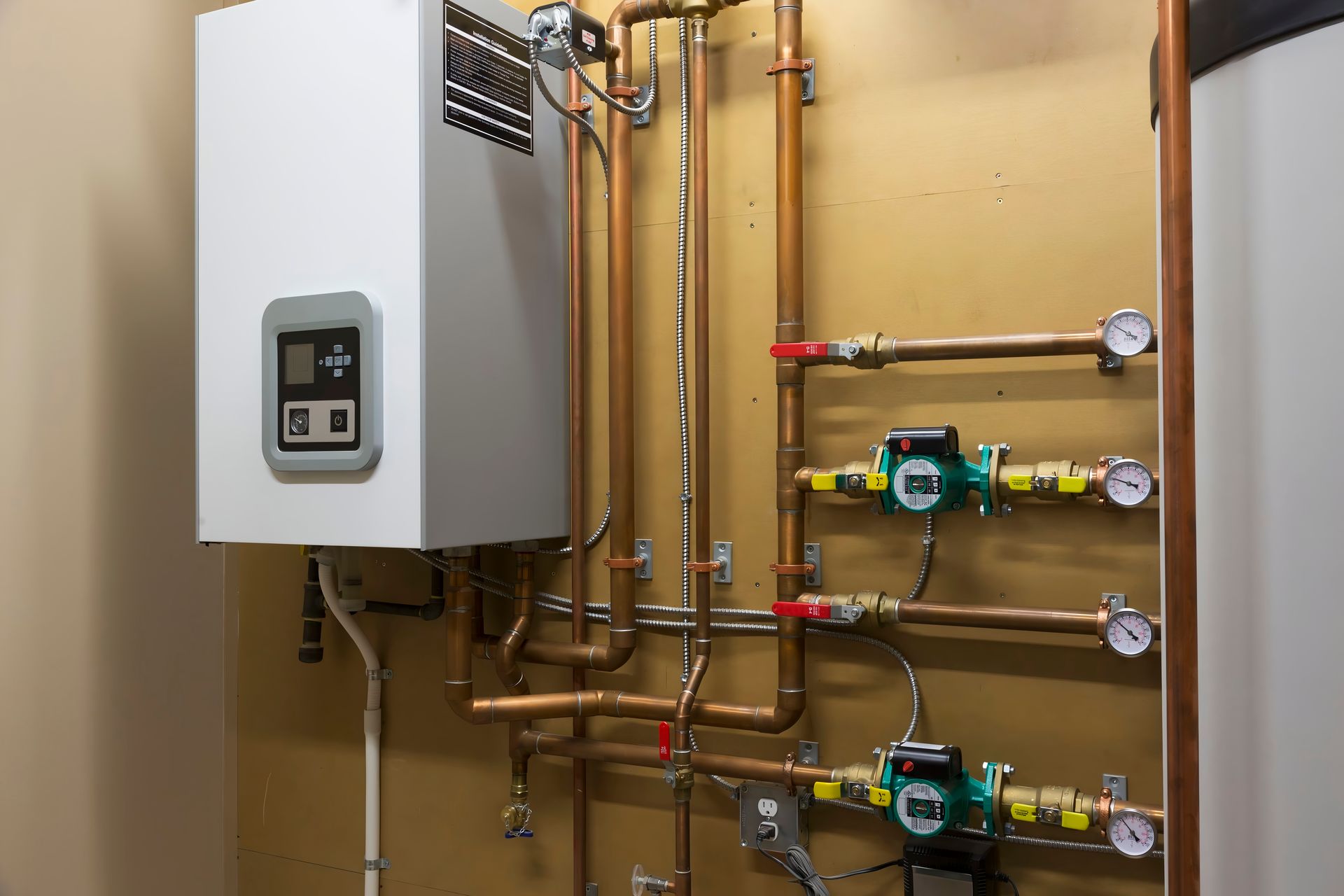 Wall-mounted boiler and copper plumbing pipes with gauges in a utility room