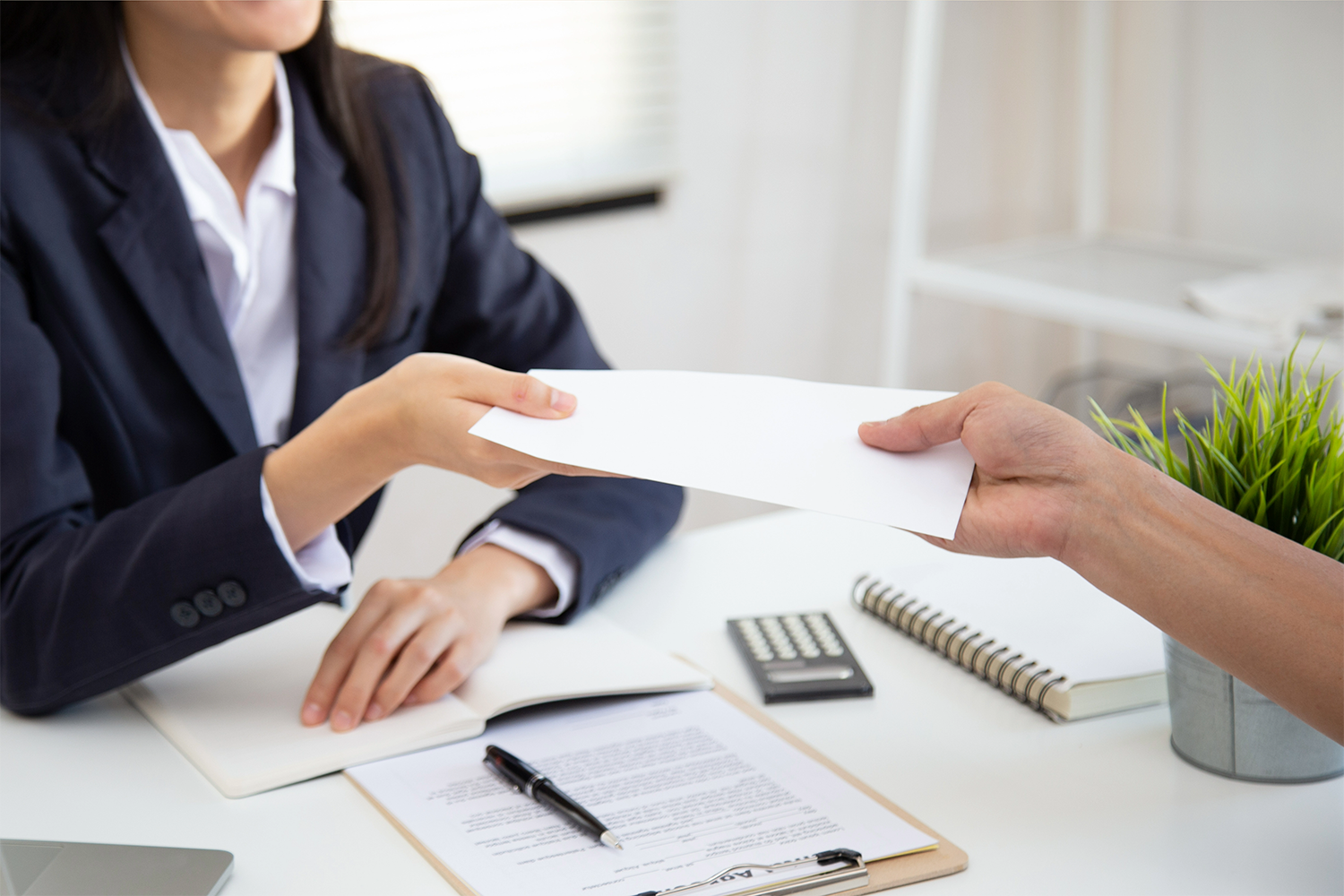 A person handing a piece of paper to another person.