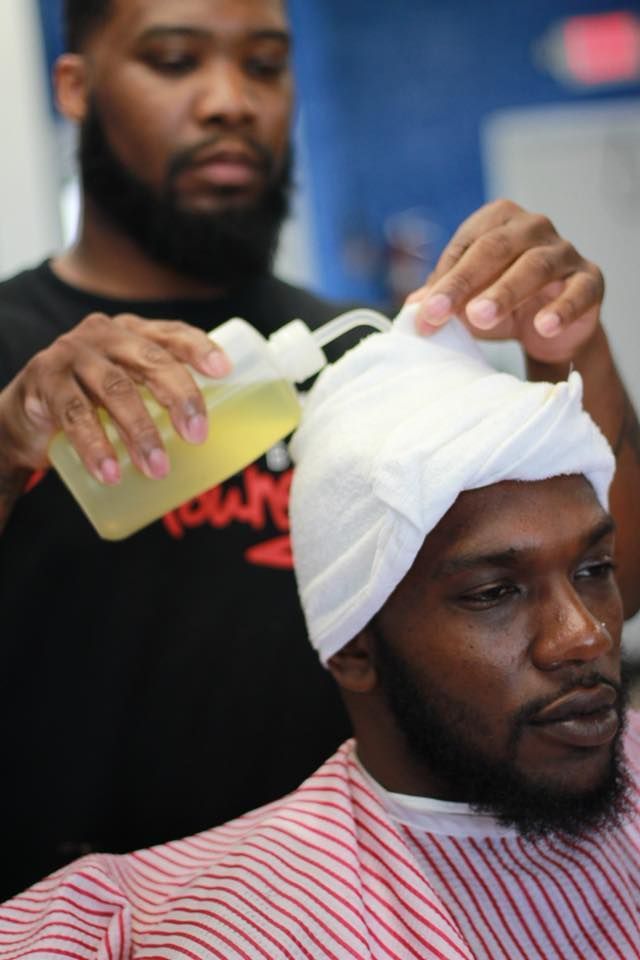 A man is getting his hair cut by a barber in a barber shop.