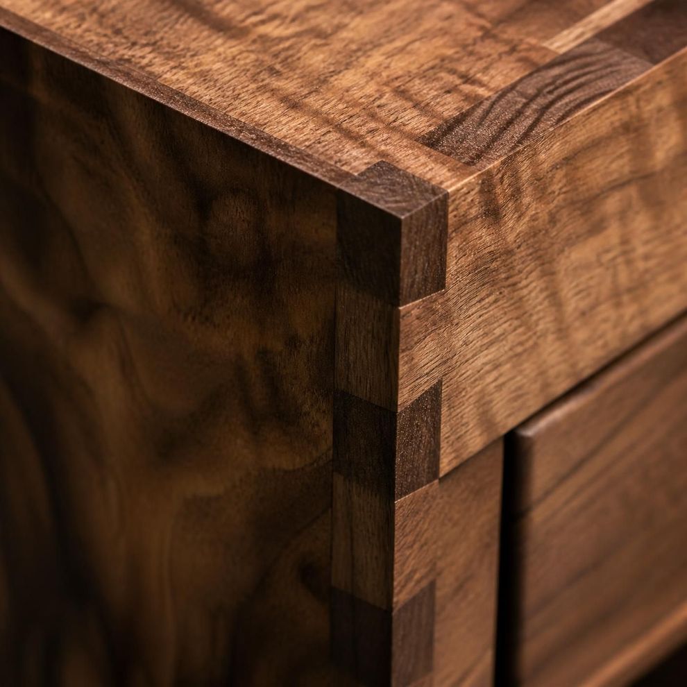Close-up of a wooden box corner with dark inlay and visible grain