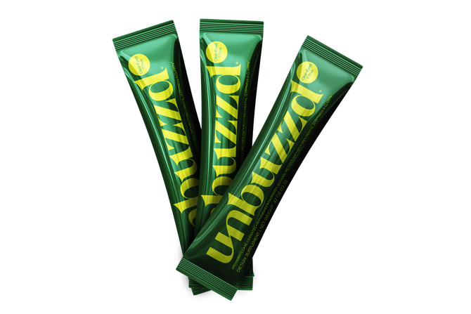 Three green packets of unbuzzd are stacked on top of each other on a white background.
