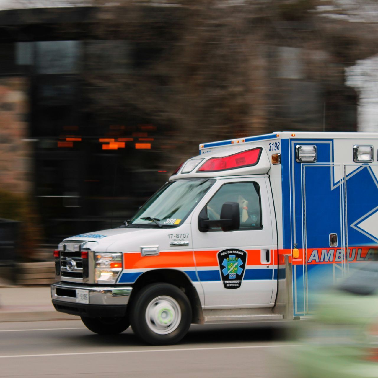A blue and white ambulance is driving down the street