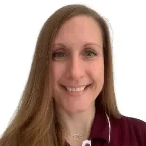 Smiling person with long brown hair wearing a maroon top against a white background