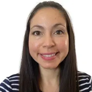 Smiling woman with long dark hair in a navy-and-white striped shirt against a white background