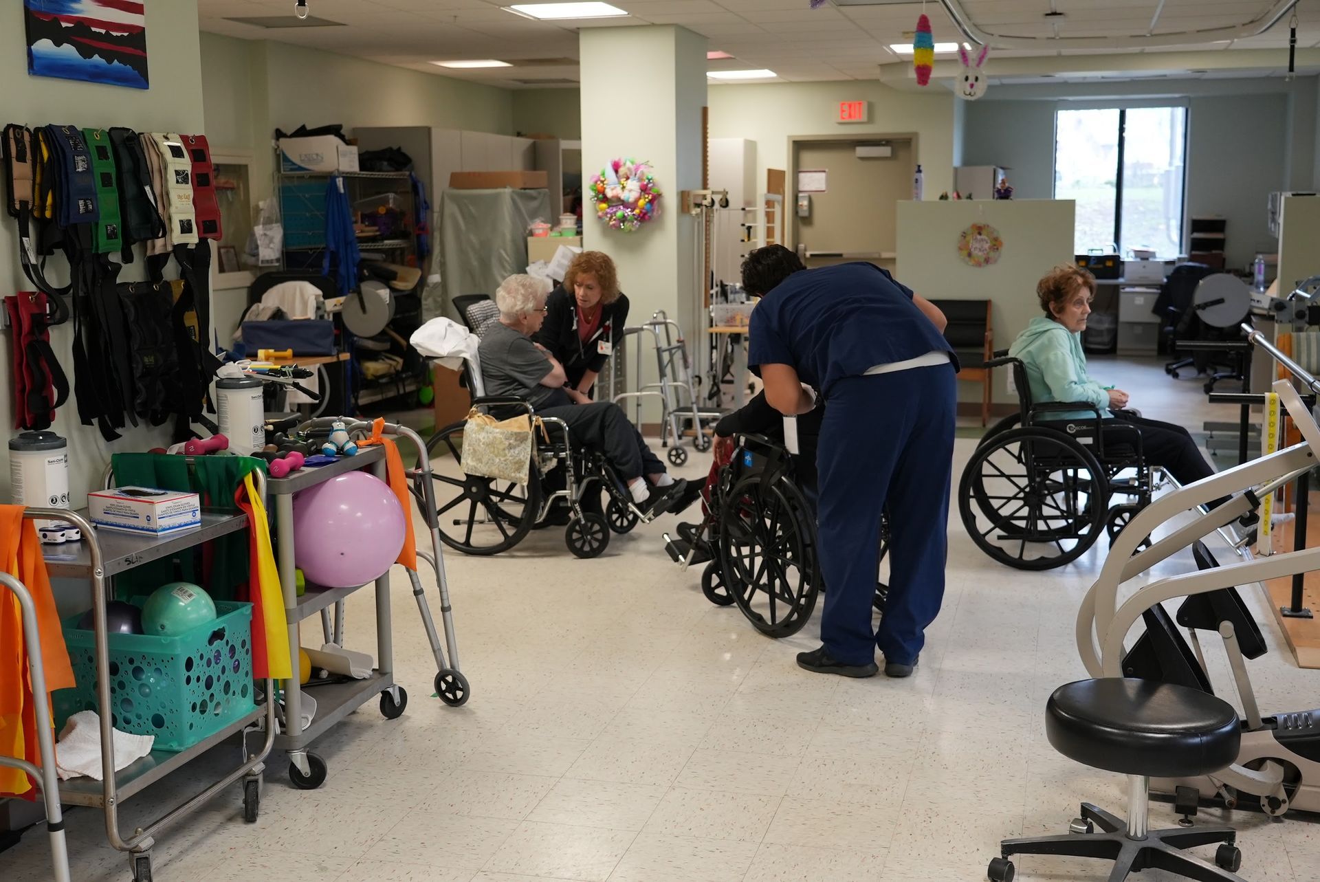 People in a rehabilitation gym using wheelchairs and exercise equipment