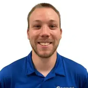 Smiling person in a blue collared shirt against a white background