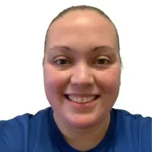 Smiling person in a blue shirt against a plain white background