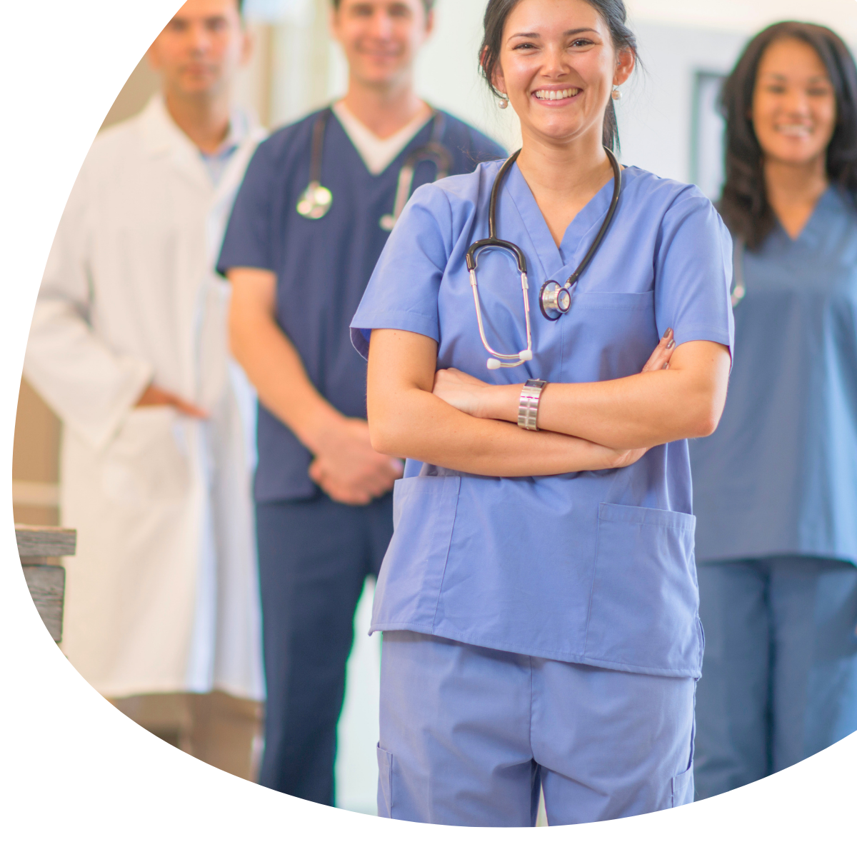 Medical staff in scrubs, with a smiling nurse in blue in front