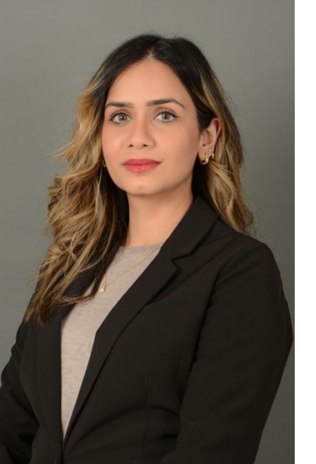 Portrait of a woman in a black blazer and gray top against a plain gray background