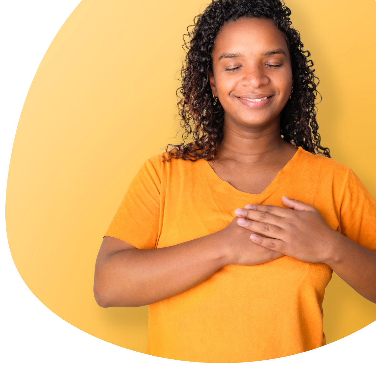 Smiling person in an orange shirt with hands clasped over chest on a yellow background