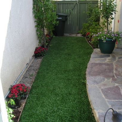 fake grass between house and stone