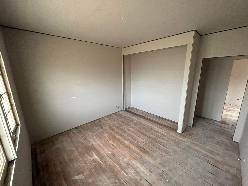 Empty Room With Wooden Floors And White Walls — Builder In Maryborough, QLD