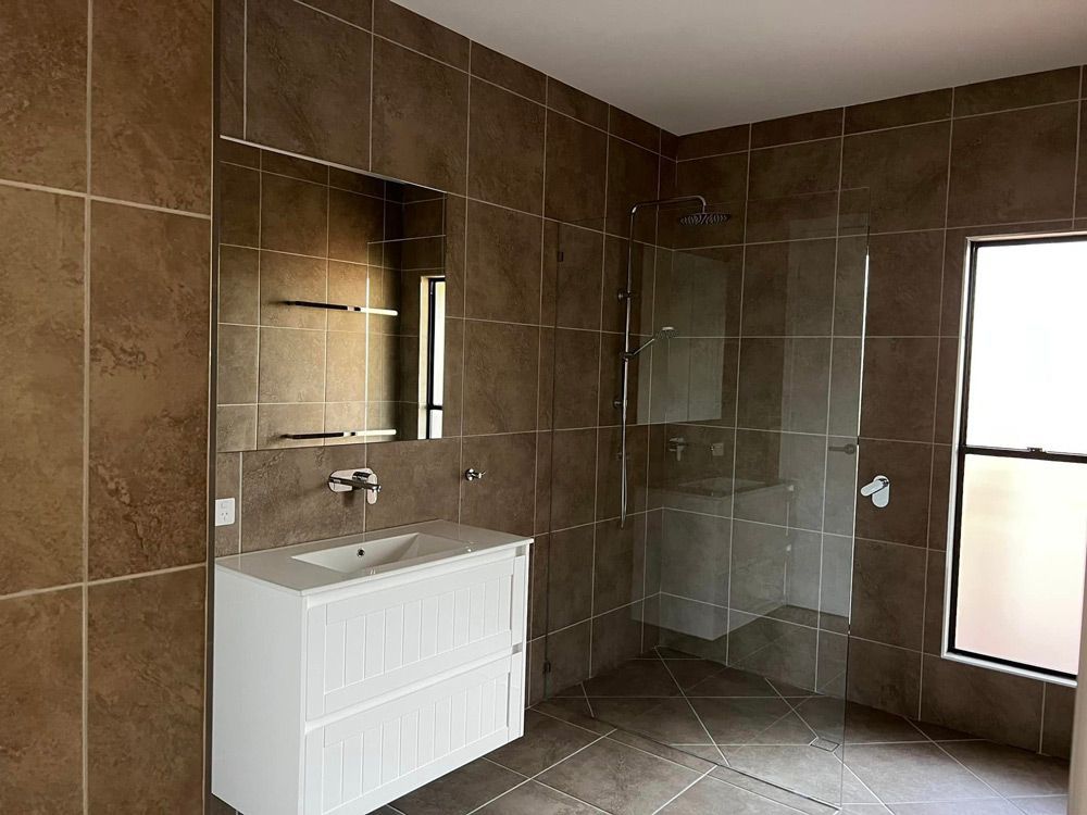 Charming Queensland Bathroom Featuring Sink, Mirror, and Shower — Builder In Sunshine Coast, QLD