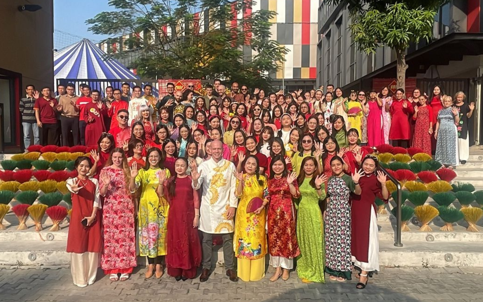Large school community group posing outdoors during a cultural celebration, illustrating community engagement.